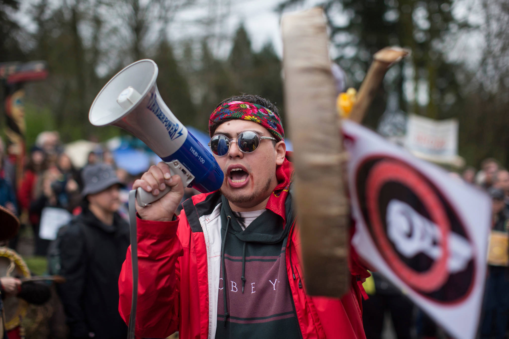 In this Saturday, April 7, 2018, photo, Cedar George-Parker addresses the crowd as protesters opposed to Kinder Morgan’s plan on Trans Mountain pipeline extension, in Burnaby, British Columbia. Kinder Morgan is suspending all non-essential activities and related spending on the Trans Mountain pipeline expansion project. (Darryl Dyck/The Canadian Press via AP)